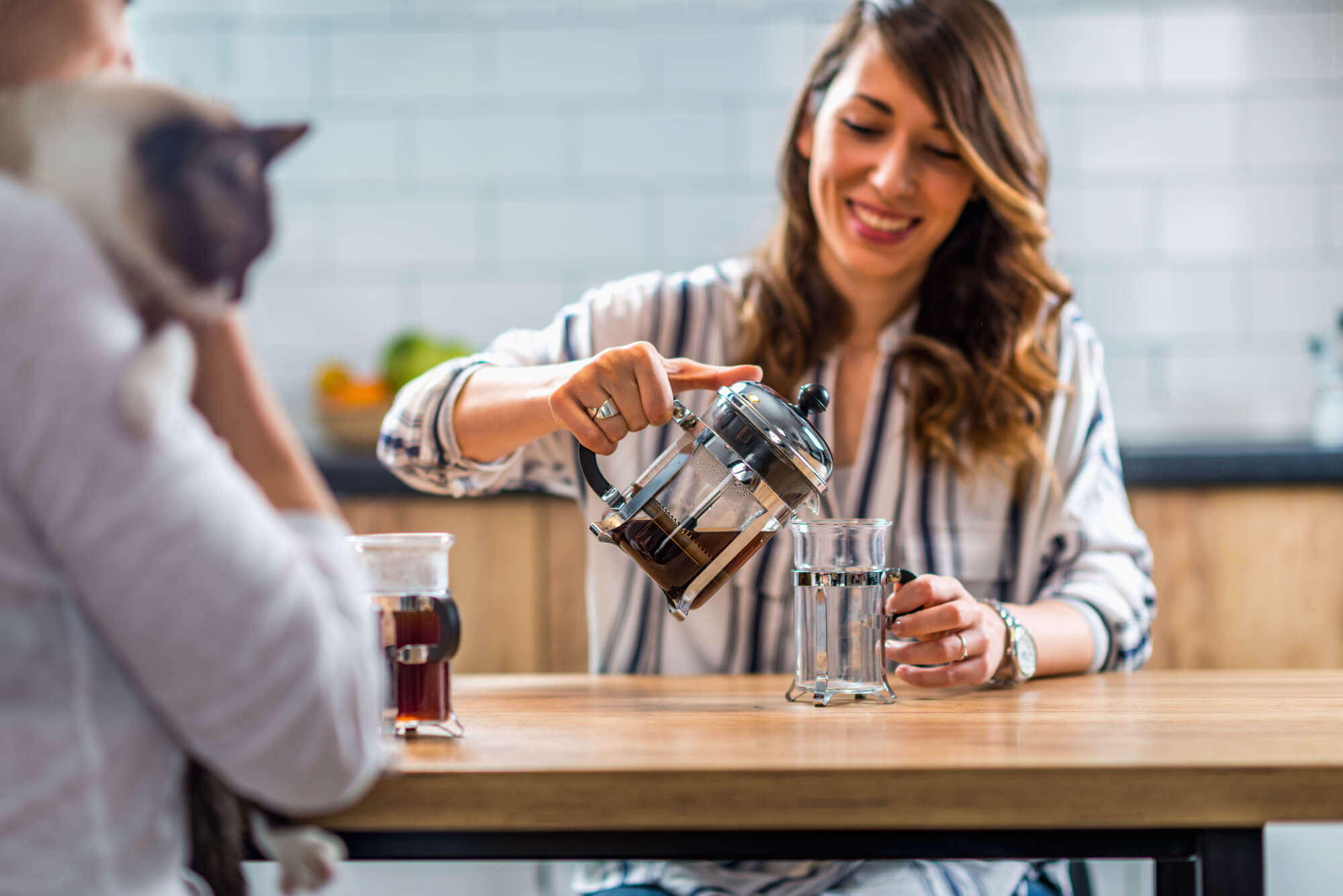 woman pouring a cup of french press drip coffee